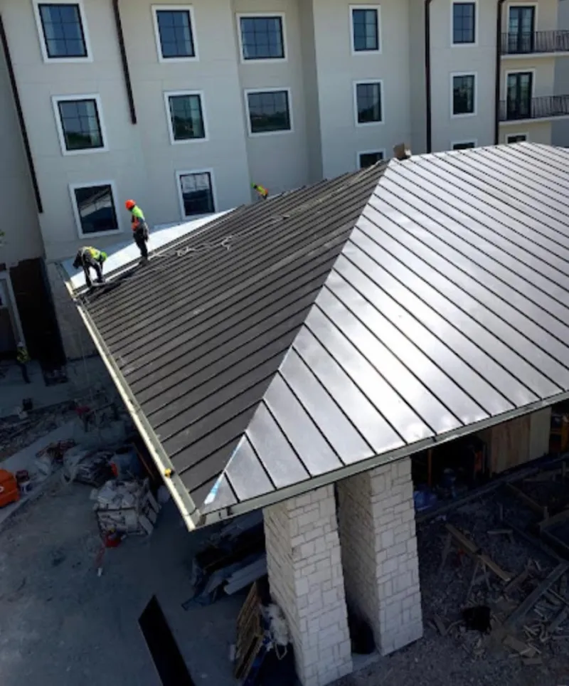 Crew installing standing seam metal roof panels on a commercial project in Ladera Heights